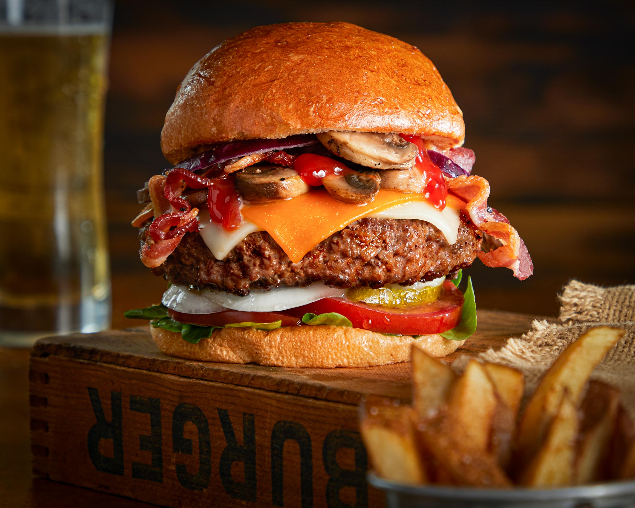Pub style cheese burger on a dark wood background.