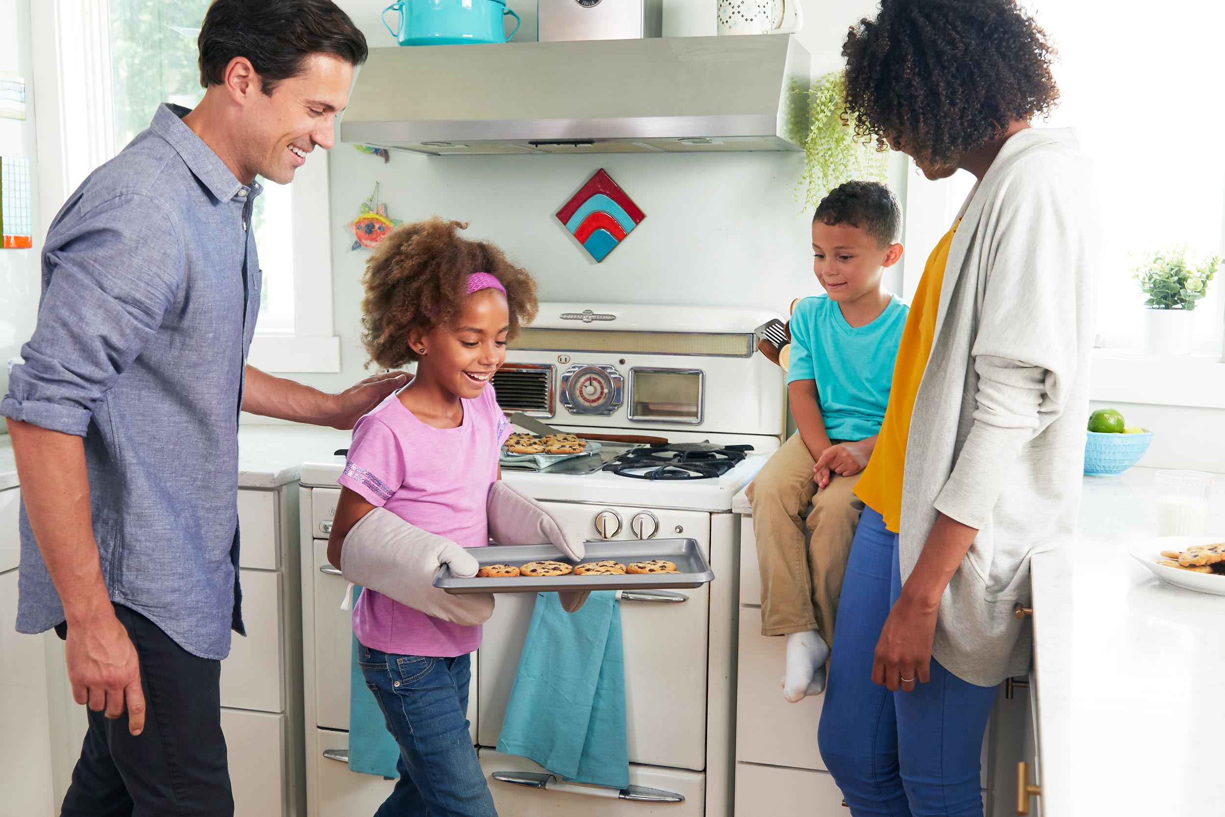Family in a sunny kitchen baking cookies
