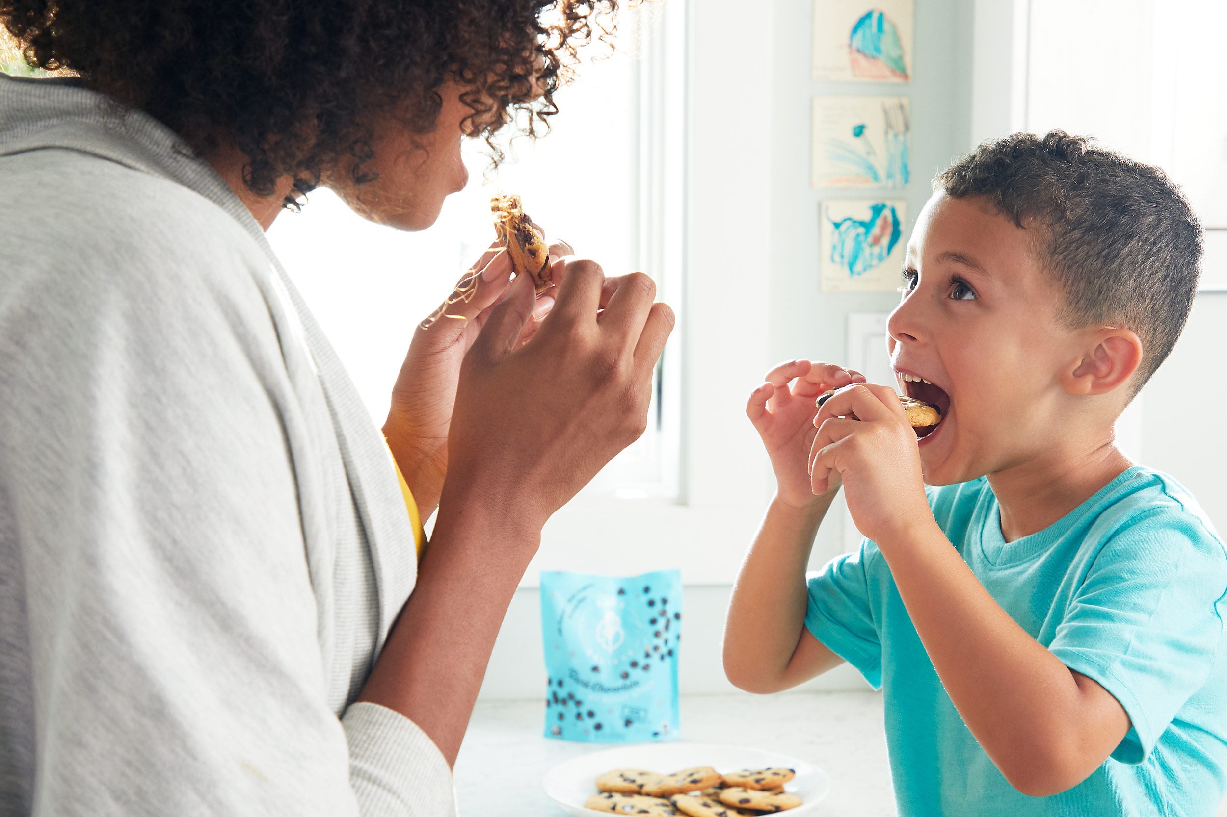 Mom and son eating cookies in the kitchen